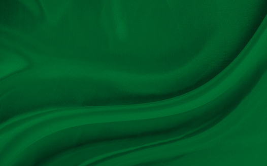 Black green satin dark fabric texture luxurious shiny that is abstract silk cloth background with patterns soft waves blur beautiful.