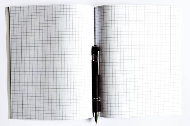 istock Top view Checkered notebook with a black pen on a white background. Place for text.Copy space. 1803719896
