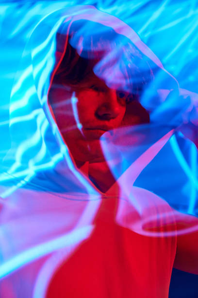 istock Portrait with long exposure. Young man, calm guy posing in futuristic digital projector reflection and in vivid neon light. 1803720153