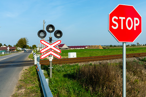 Railroad crossing and stop sign in farmland ralway level crossing with warning sign stop nobody outdoor evening
