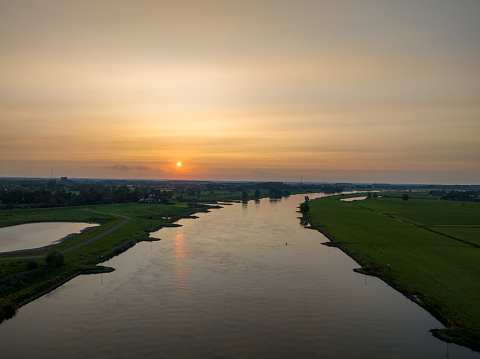 IJssel sunrise panoramic landscape view during a late summer morning near Zwolle. The river on the border of Overijssel and Gelderland is winding into the distance.