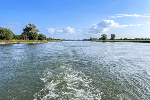 Sailing on the river IJssel panoramic landscape view during a late say near Vorchten. The river on the border of Overijssel and Gelderland is winding into the distance.