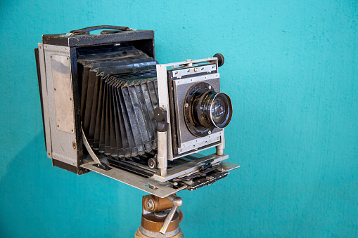 Vintage camera on turquoise background. Old photo camera