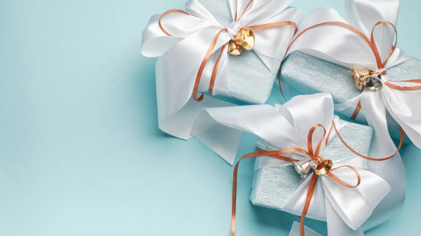 istock Gift boxes wrapped in blue and silver paper with white and gold ribbon bows. Blue background, top view. Christmas and New Year gifts, Boxing Day. 1803748033