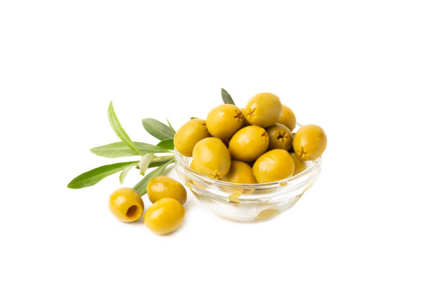 istock Delicious green olives isolated on white background. Olive and olive tree branches on a white table. Delicacy. 1803752448
