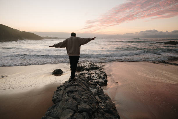 istock Person balancing on beach rocks 1803755307