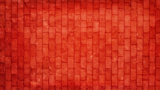 Horizontal illustration of a bright rust coloured illuminated brick wall with rectangular blocks in a textured grungy backgrounds. The wall is rough, uneven, empty and blank with no people and copy space.