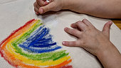 Caucasian kid drawing a rainbow on a reusable material bag
