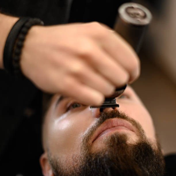 istock A barber trims a Caucasian clients mustache with a trimmer. 1803763056