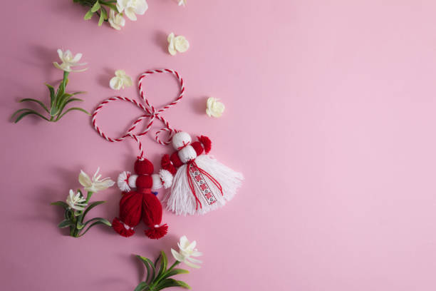 martenitsa, martisor tra i fiori primaverili su uno sfondo rosa spazio di copia piatto - moldavia europa orientale foto e immagini stock