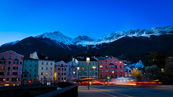 The long exposure night view in Innsbruck  as city center town with beautiful houses, river Inn and Tyrol Alps, Austria