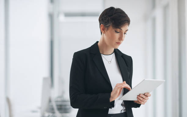 istock Woman, business and typing on tablet in office for online communication, networking or web research. Female person, digital marketing and reading touch screen for project, scroll or connectivity idea 1803777135