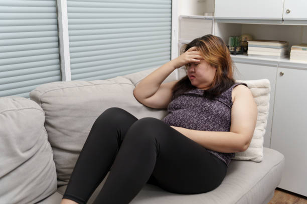 istock Sad Overweight plus size woman thinking about problems on sofa upset girl feeling lonely and sad from bad relationship or Depressed woman disorder mental health 1803780556