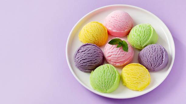 istock Pastel colored ice cream scoops and cones frame on pastel violet background 1803793711
