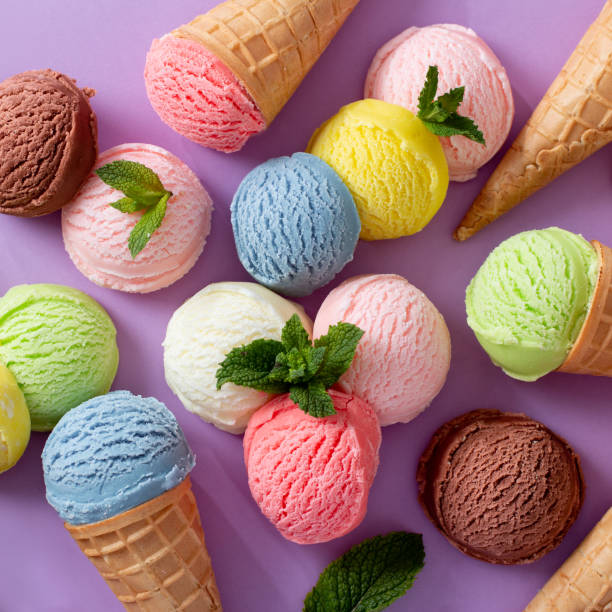istock Pastel colored ice cream scoops and cones frame on pastel violet background 1803793848