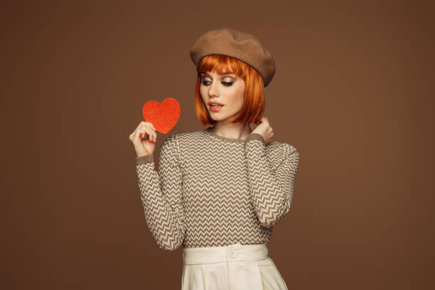 Beautiful emotional woman holding artificial heart