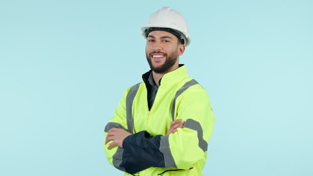 Face, architect and happy man with arms crossed in helmet at studio isolated on blue background mockup space. Portrait, engineer and confident professional in hard hat for construction work in Brazil