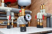 A pressure gauge indicating 2 bar placed on a modern heat pump in the boiler room.
