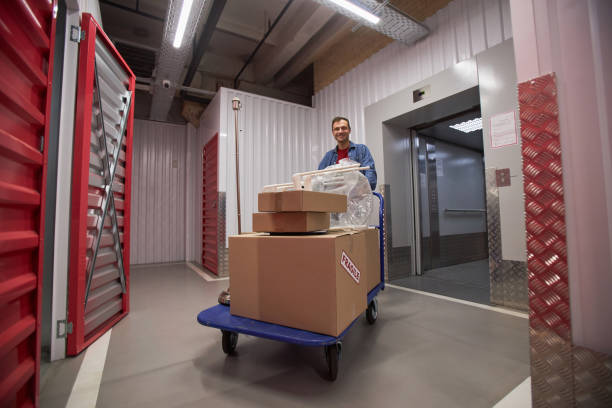 istock Man Pushing Cart in Storage Facility 1803820823