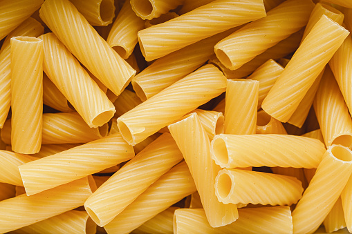 Full frame of dried pasta. Raw uncooked Rigatoni pasta.