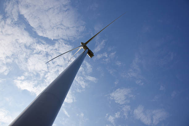 istock wind turbine as silhouette against blue sky 180384871
