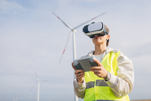 Woman using VR glasses to control windmills