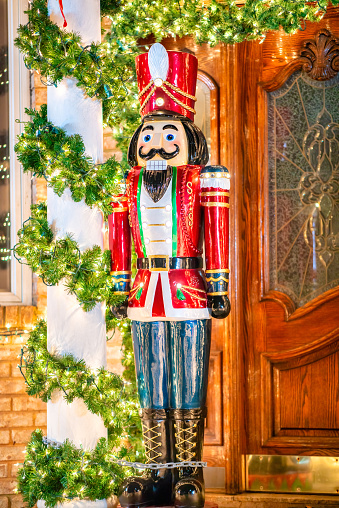 Nutcracker in front of string lights and Christmas tree