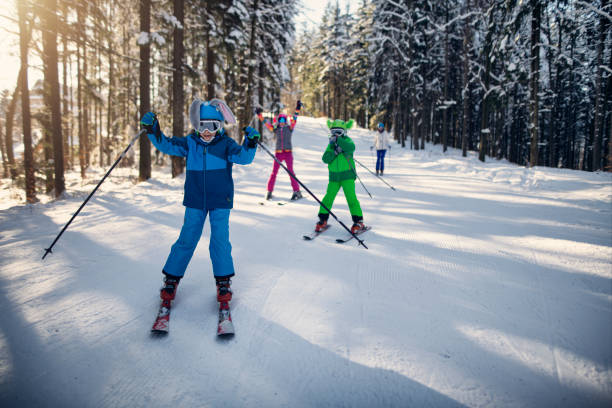 istock Family having fun skiing together on ski slope in forest 1803872255