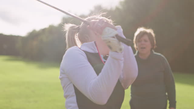 Golf, training and women on grass together for coaching, teaching and fun game. Tee off, green course and woman with professional instructor, swing and support for learning, competition and challenge