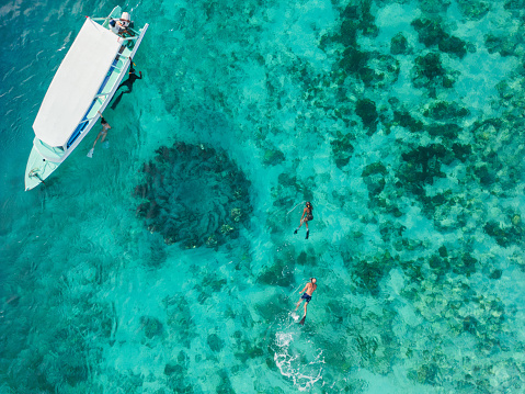 Aerial view of  group of people snorkelling near underwater statues on Gili Meno