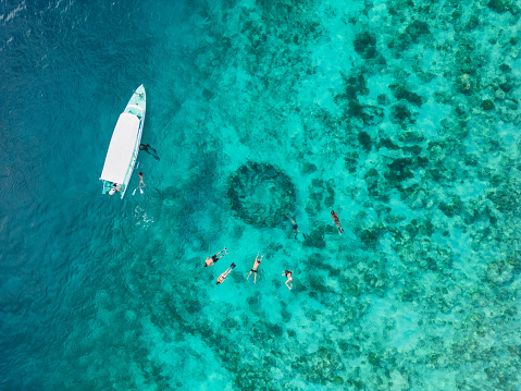 Aerial view of  group of people snorkelling near underwater statues on Gili Meno