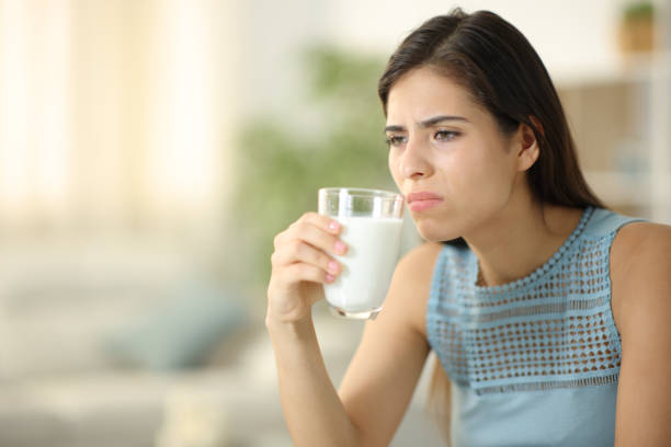 istock Disgusted woman smelling expired milk 1803898762