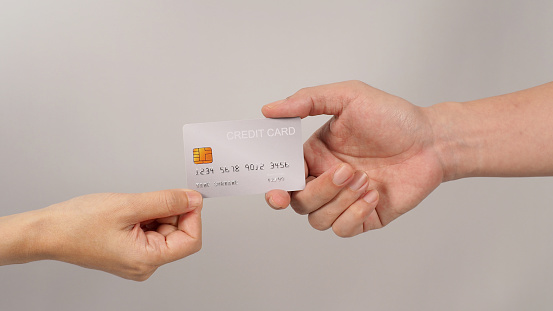 Two hands is hold a silver credit card on white background.
