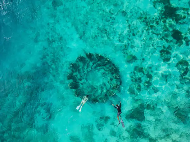 Aerial view of couple snorkelling near the underwater statues  on their romantic getaway to Gili Meno islands