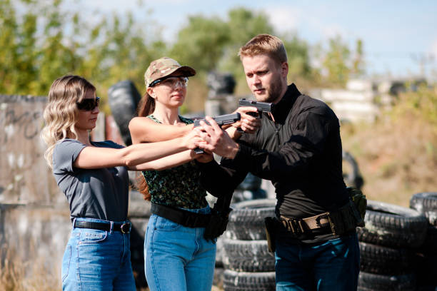 istock Girls learn to shoot a pistol at a shooting range with an instructor 1803903003