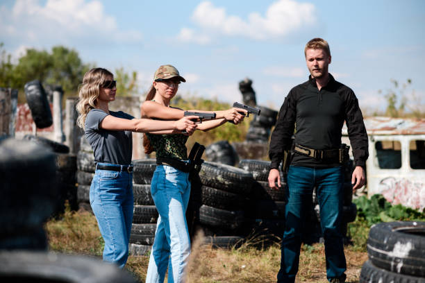istock Girls learn to shoot a pistol at a shooting range with an instructor 1803904345
