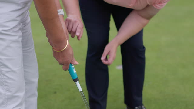 Sport, coach and woman training in golf on course for development in stroke and swing of club. Hands, closeup and mentor holding stick for player, athlete and student learning on pitch in sports game
