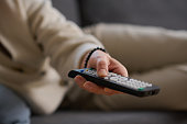 Woman using remote control to watch TV