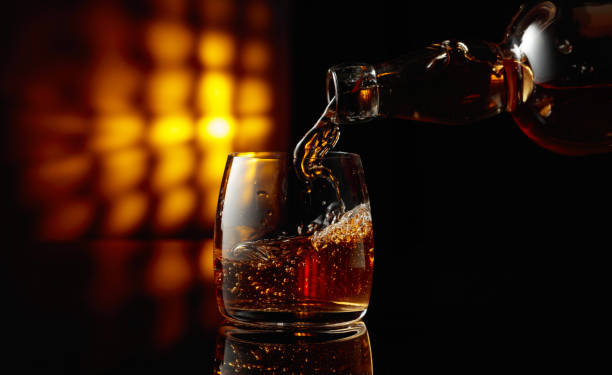 istock Pouring whiskey from a bottle into a glass. 1803945699
