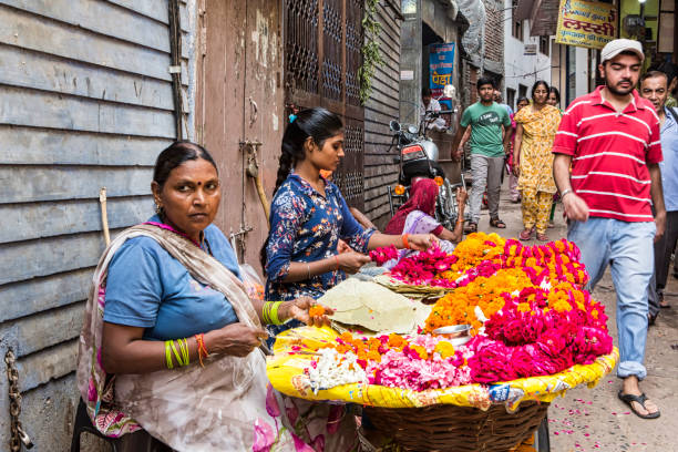 Vrindavan, Uttar Pradesh, October 19th 2019: Indian woman florist selling her flower products in morning time at the streets of Vrindavan