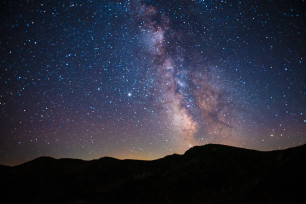 istock Glowing stars on evening sky over mountain peaks 1803956974