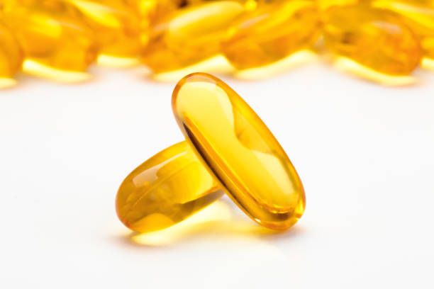 istock Fish oil softgel capsules scattered on a white table, focus on foreground 1803956977
