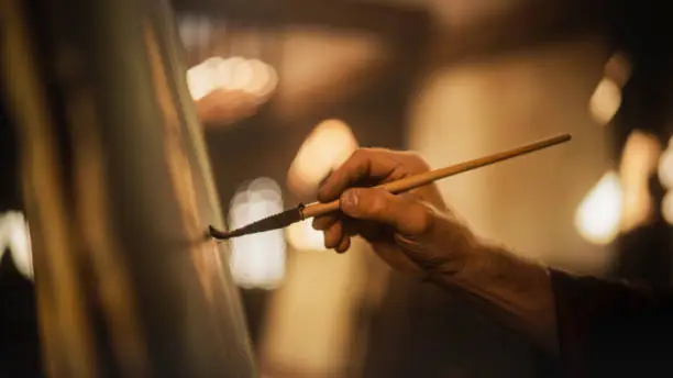 Photo of Close Up on Male Painter Hand Painting the Mona Lisa with Gentle Brush Movement. Details of the Famous Painting Being Drawn by its Creator. Pure Talent and Mastery of High Art, Everlasting Beauty