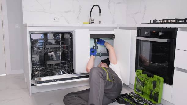 istock A repairman in overalls inspects a kitchen sink after installing it. Plumbing services 1803966421