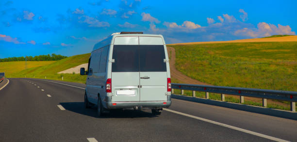 istock Minibus Carries Passengers on a suburban Highway 1803974400