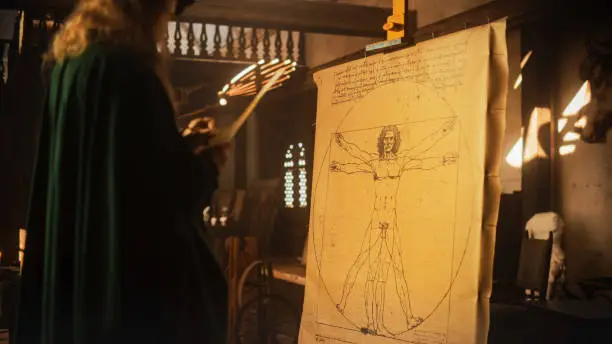 Photo of The Blend of Art and Science: Documentary Shot of Leonardo Da Vinci Working on his Famous Piece of the Vitruvian Man in his Workshop. Historical Moment Depiction of Talent and Brilliance