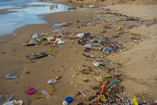Plastic trash on sand sea beach wave nature pollution in Pattaya Thailand