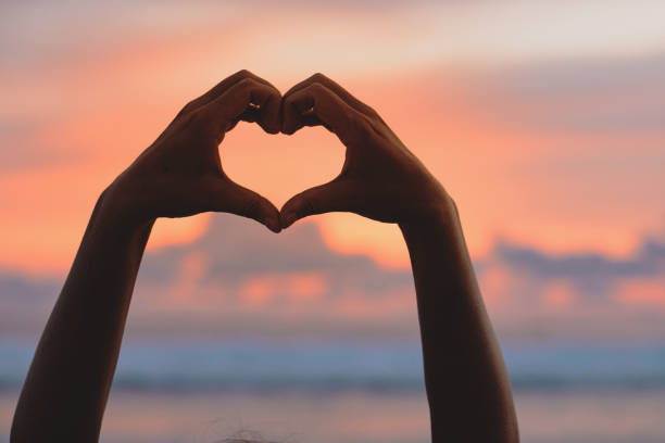 istock Hands forming a heart shape with sunset silhouette 1804005747