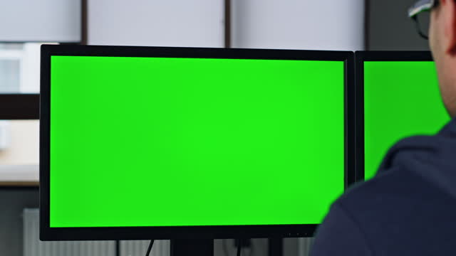 Two green pc monitor in office closeup. Professional designer manager working