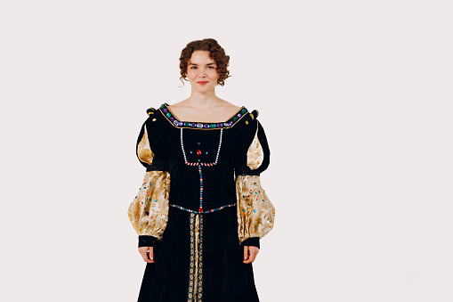 Portrait of a young aristocratic woman dressed in a medieval dress on white background. Front view